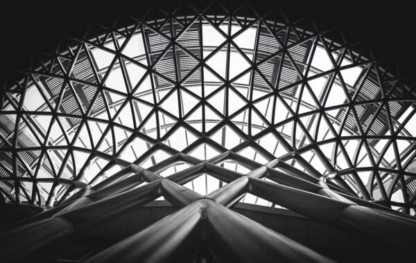 Low Angle Photography of Metal Building on Grayscale